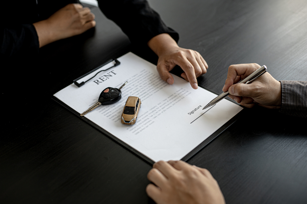 Individual reviewing extra car rental fees agreement terms
