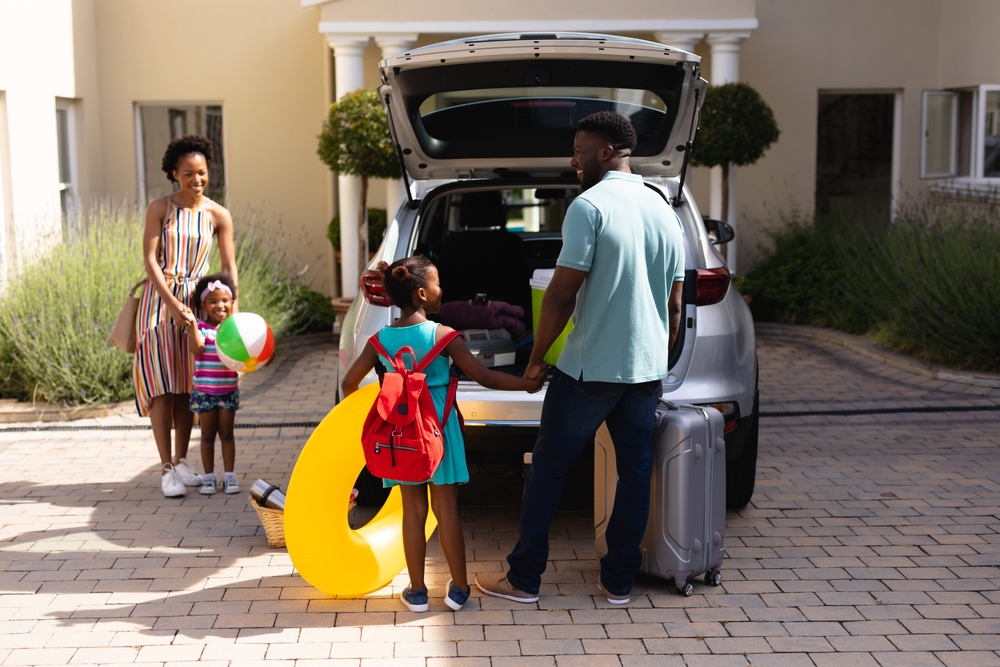 Family preparing spacious rental car for holiday travel with kids
