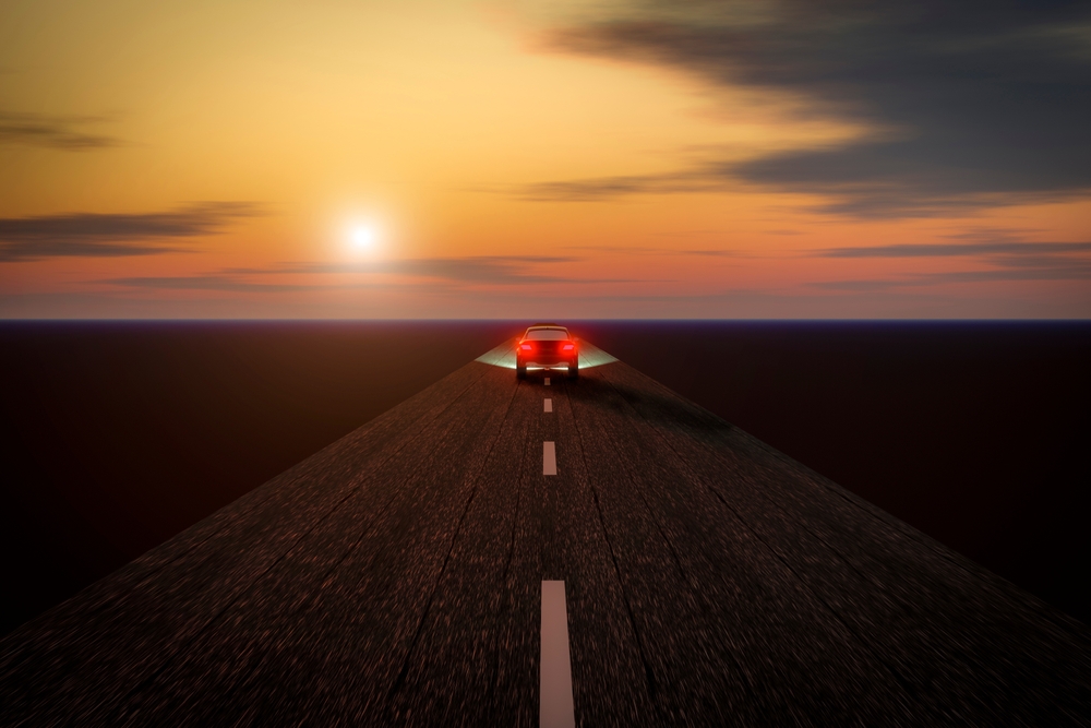a scenic road with a car traveling towards the horizon