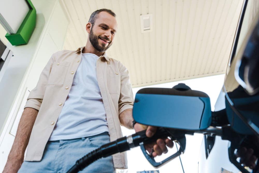 Driver filling up gas tank before returning rental car to avoid extra car rental fees