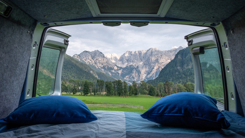 Cozy campervan bed setup with plush bedding