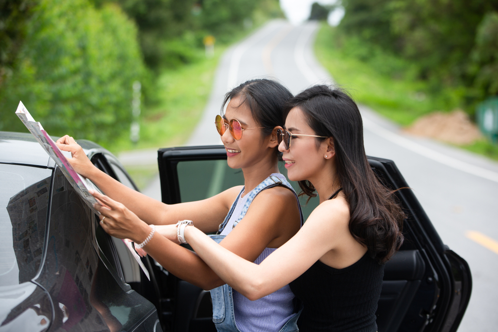 Budget travelers with affordable rental car planning road trip